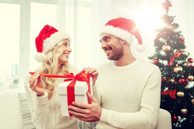 happy couple at home with christmas gift box