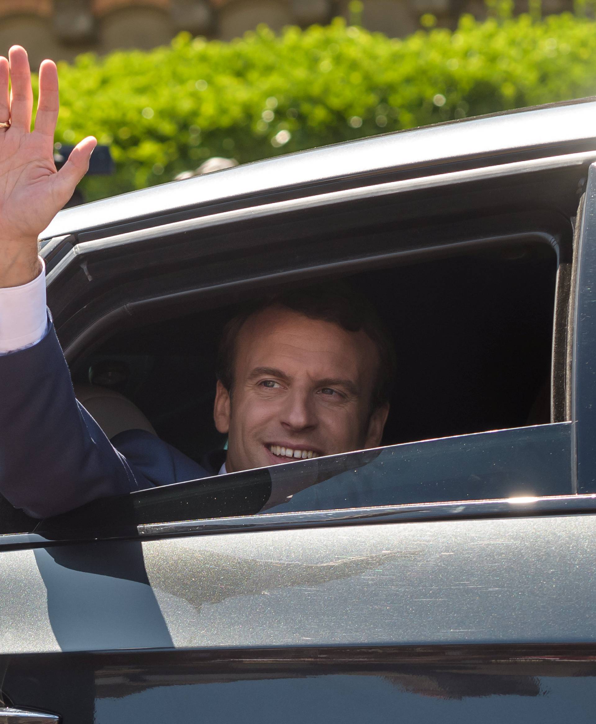 French President Emmanuel Macron waves from his car after voting in parliamentary elections in Le Touquet