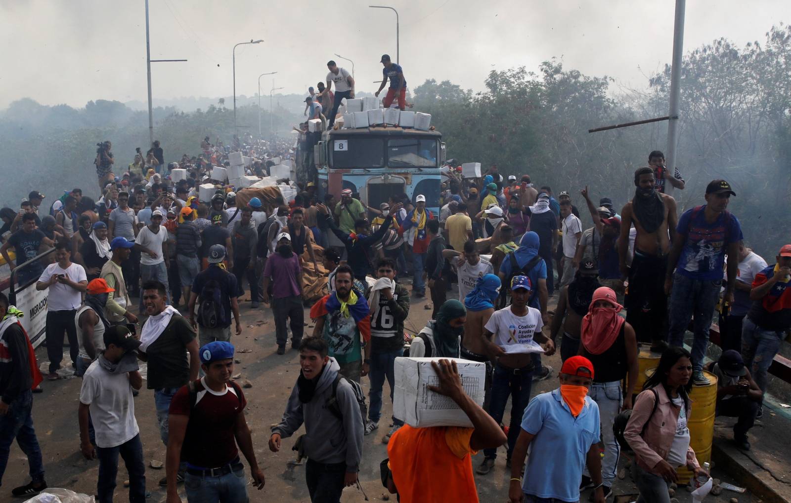 Opposition supporters unload humanitarian aid from a truck that was sent on fire in Cucuta