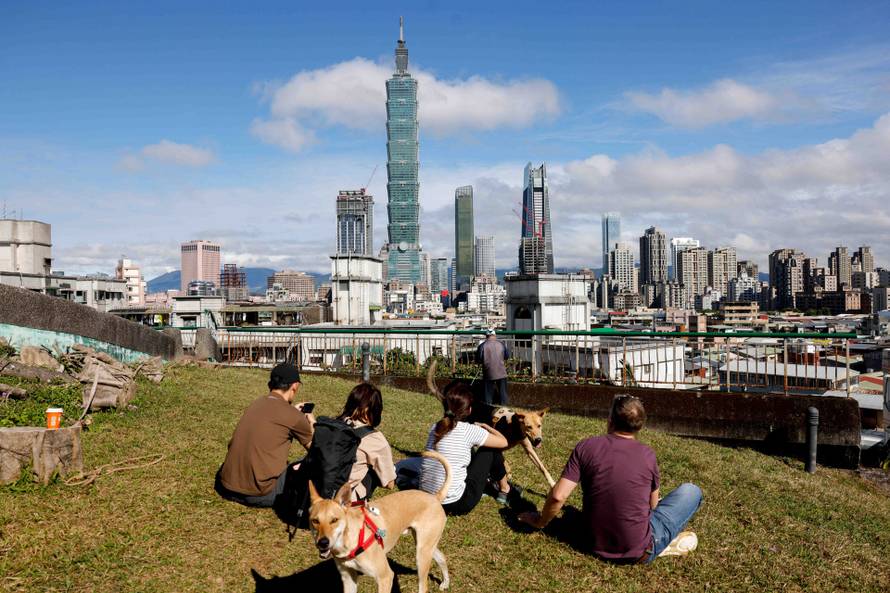 People gather to watch climber Alex Honnold free soloing Taipei 101 Skyscraper in Taipei