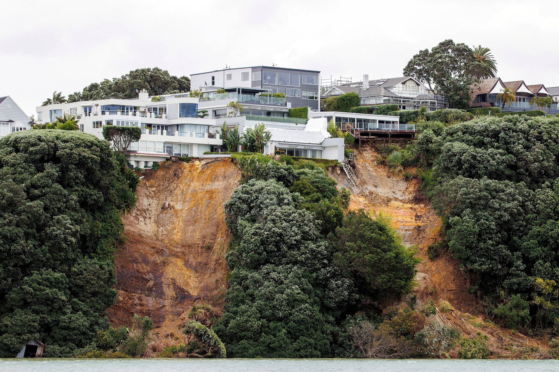 A slip near a house on a clifftop caused by continuous bad weather as Cyclone Gabrielle approaches in Auckland