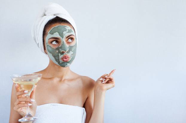 Young beautiful woman in face mask of therapeutic blue mud. Spa 