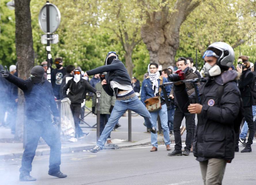 Masked youths face off with French police during a demonstration against the French labour law proposal in Paris