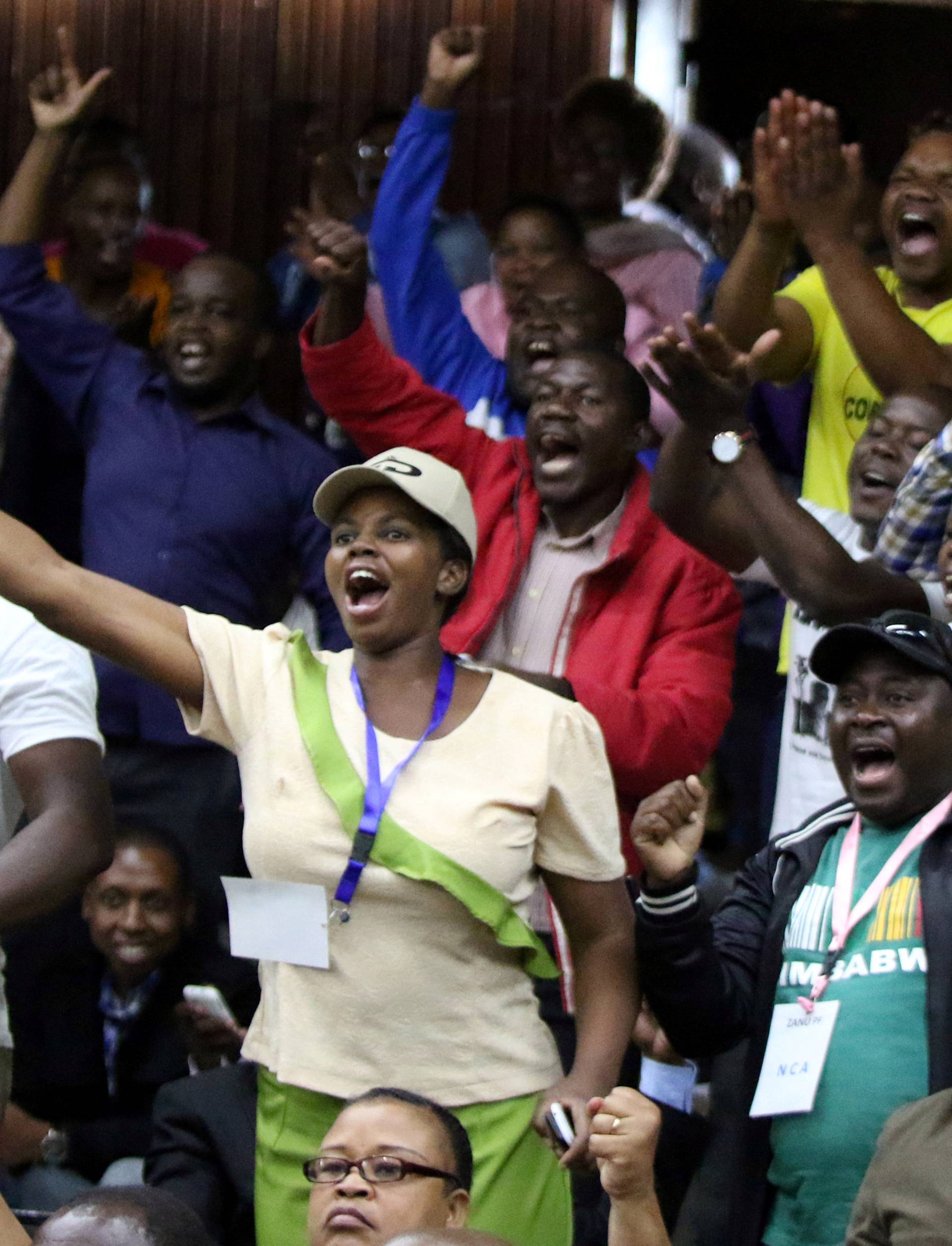 Delegates celebrate after Zimbabwean President Robert Mugabe was dismissed as party leader at an extraordinary meeting of the ruling ZANU-PF's central committee in Harare