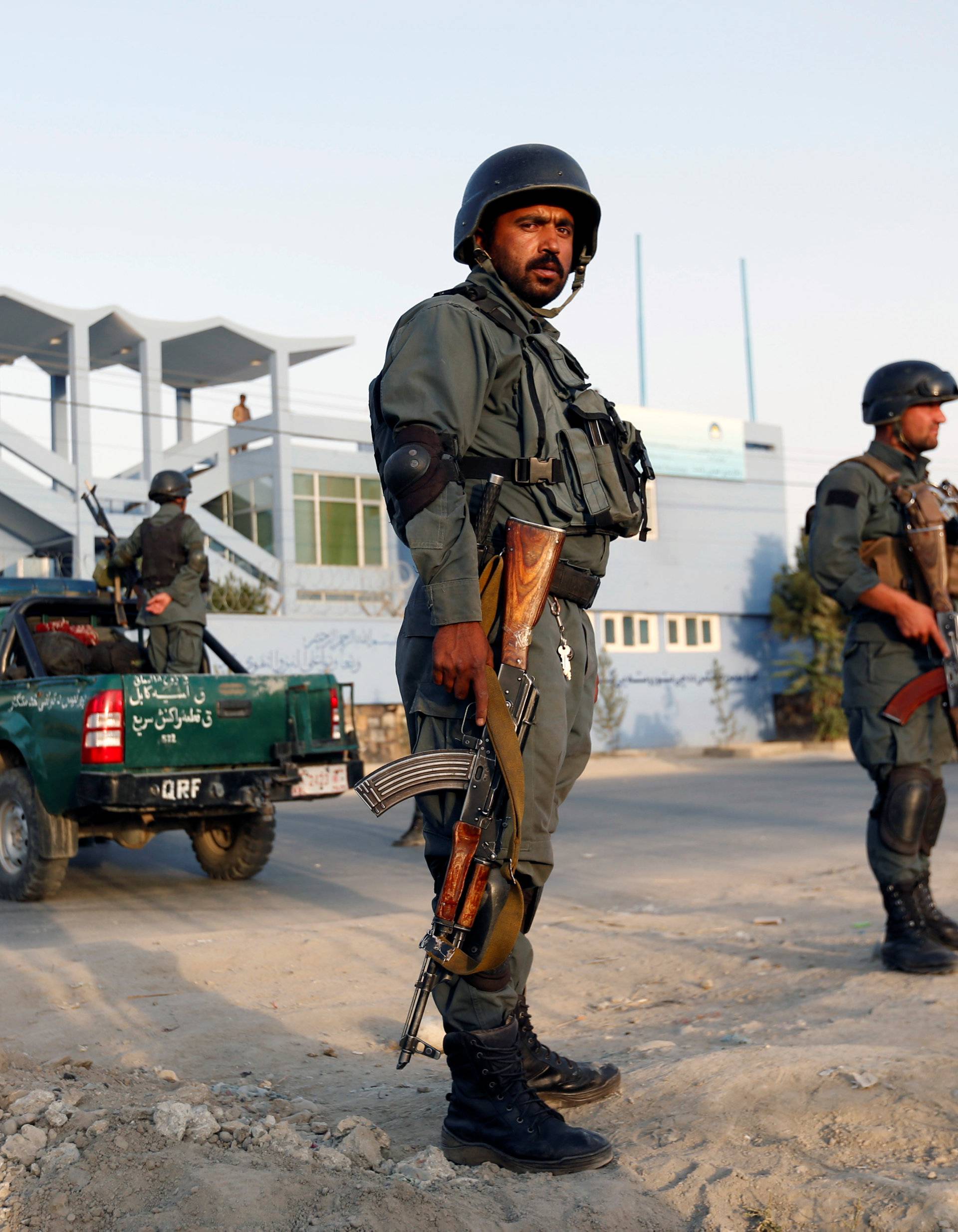 Afghan police officers stand guard at the site of a suicide attack in Kabul, Afghanistan