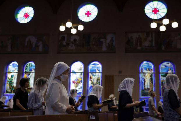 Local residents pray for victims during a mass on the 78th anniversary of the atomic bombing of the city, in Nagasaki