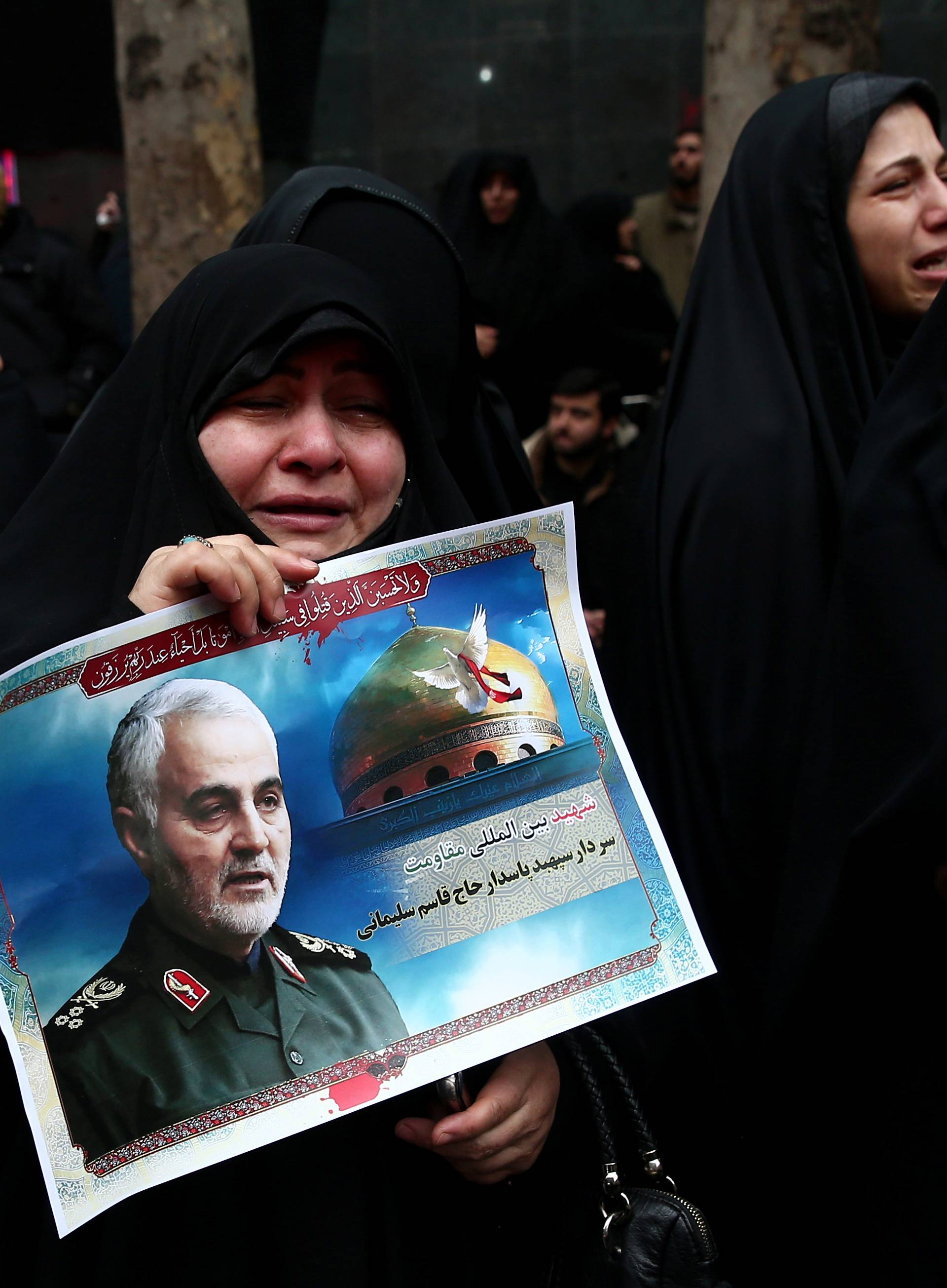 Iranian women react as they gather to mourn General Qassem Soleimani in Tehran