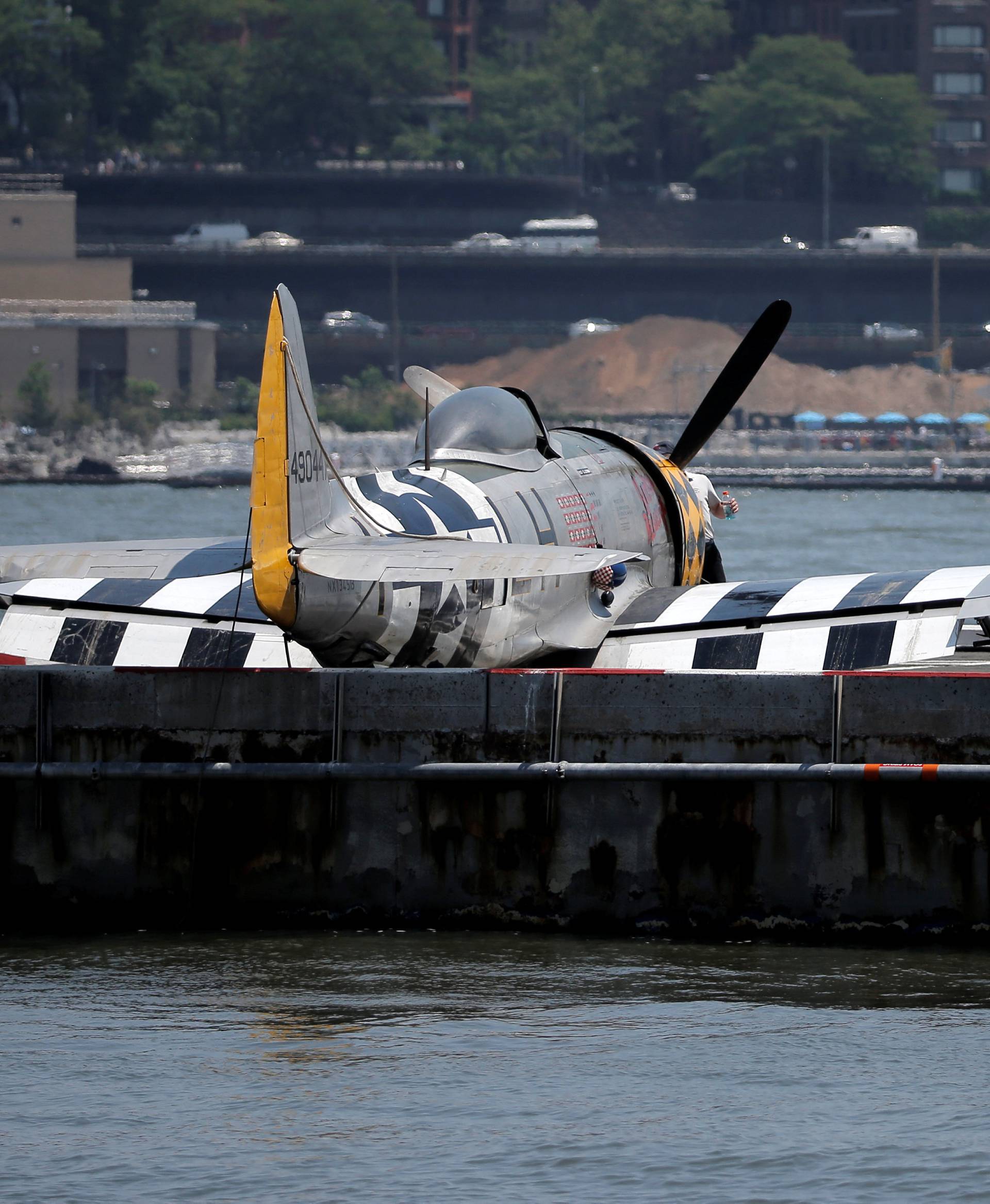 FAA investigators look over the wreckage of a vintage P-47 Thunderbolt airplane that crashed in the Hudson River in New York