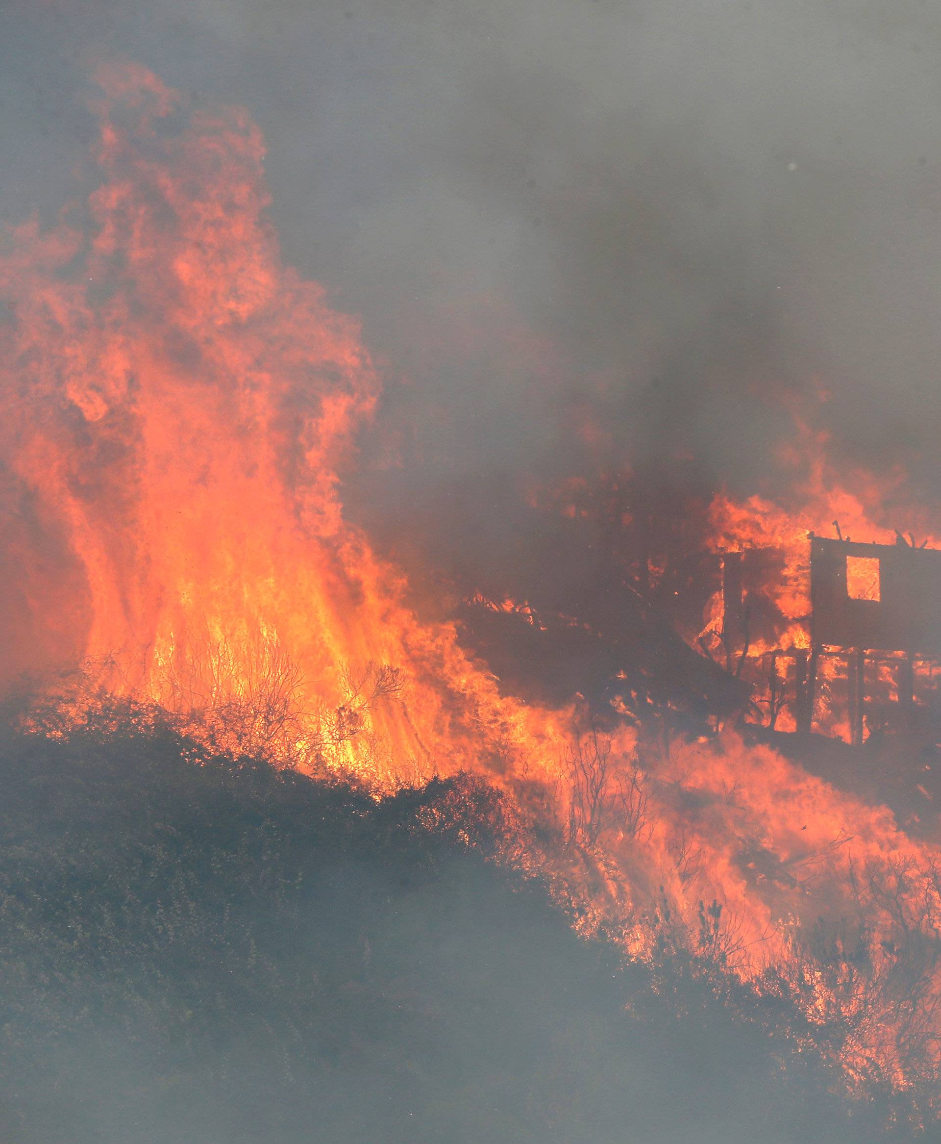 Fire burns a house on a hill, where more than 100 homes were burned due to a forest fire but there have been no reports of death, local authorities said in Valparaiso, Chile