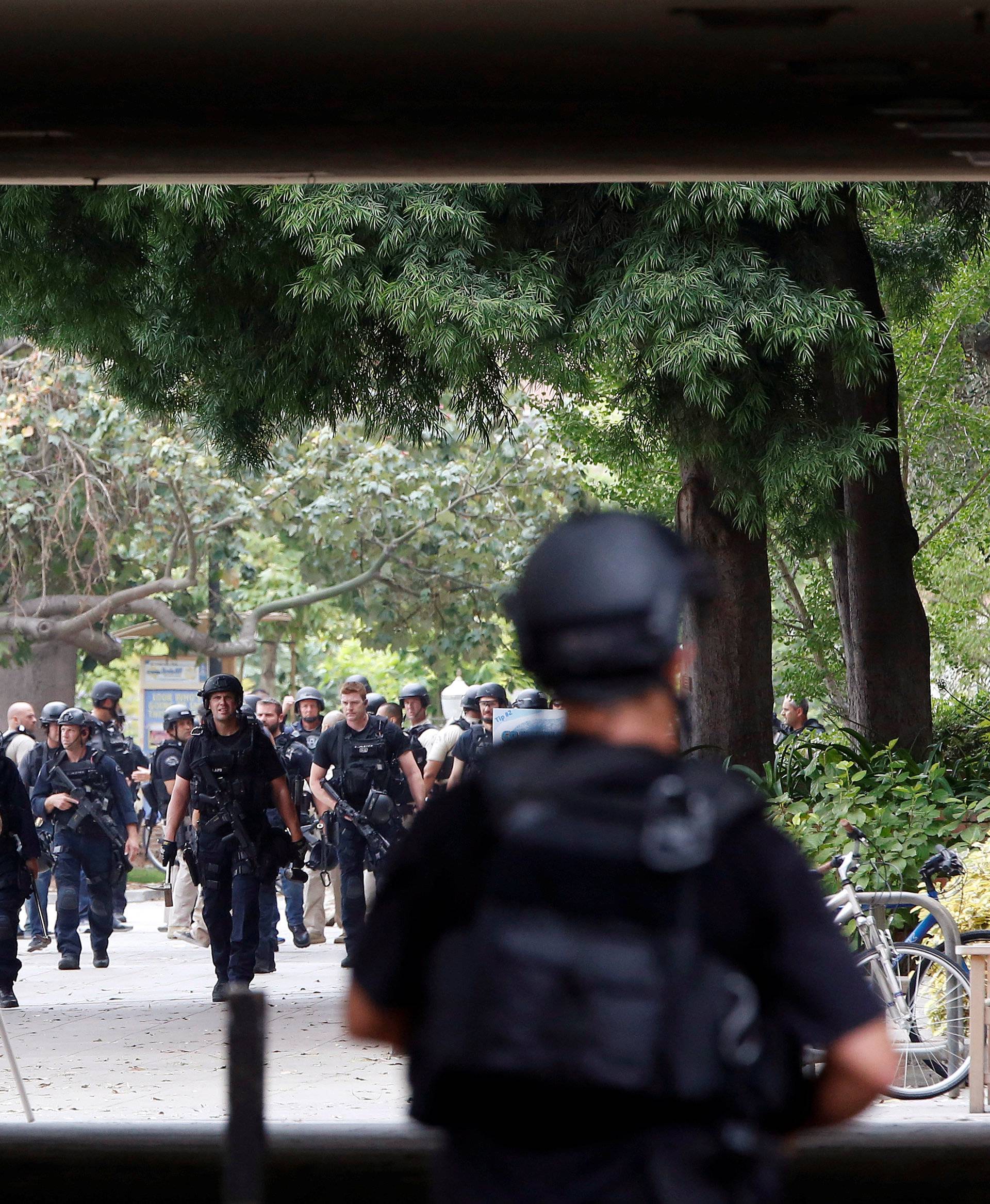 Police officers conduct a search at the University of California, Los Angeles (UCLA) campus after it was placed on lockdown following reports of a shooter that left 2 people dead in Los Angeles