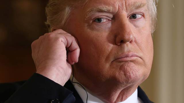 U.S. President Donald Trump listens to a translation during a joint news conference with Japanese Prime Minister Shinzo Abe at the White House in Washington