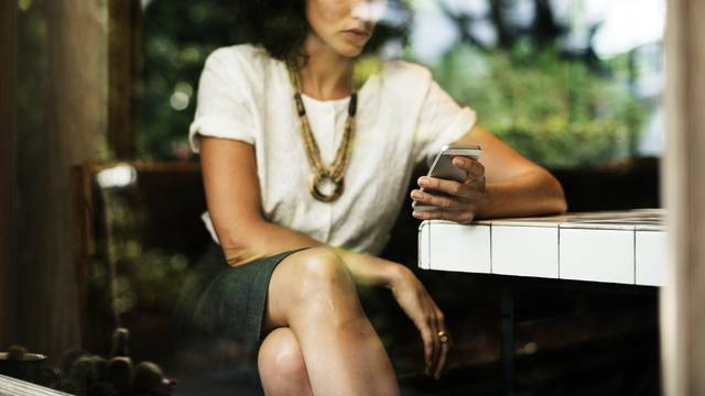 Businesswoman using mobile phone in coffee shop