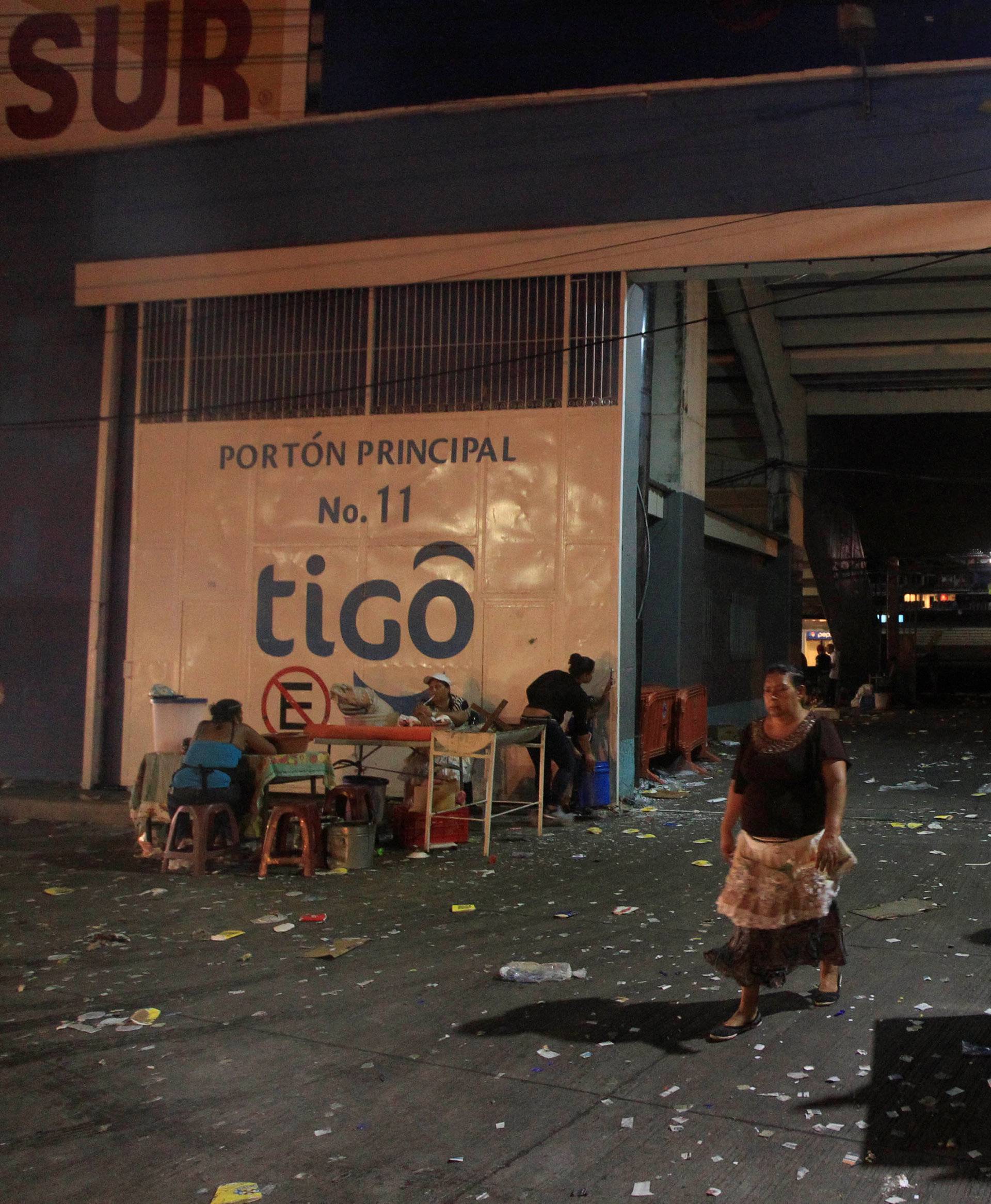 Street vendors stand outside at the National Stadium after an stampede when hundreds of fans tried to break past barricades in Tegucigalpa