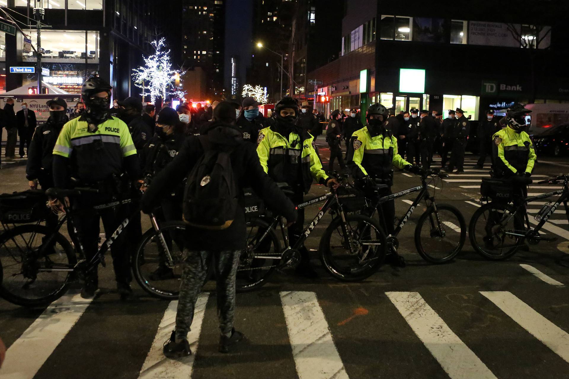 Police line up in the street at the location of a vehicle that struck multiple pedestrians on Third Avenue