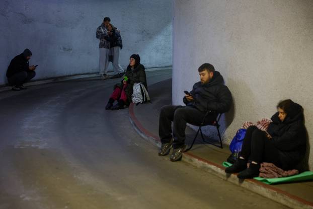 People take shelter inside an underground parking lot during a Russian missile and drone attack in Kyiv