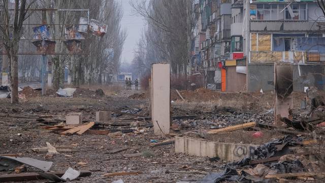 Ukrainian service members are seen an empty street in Bakhmut