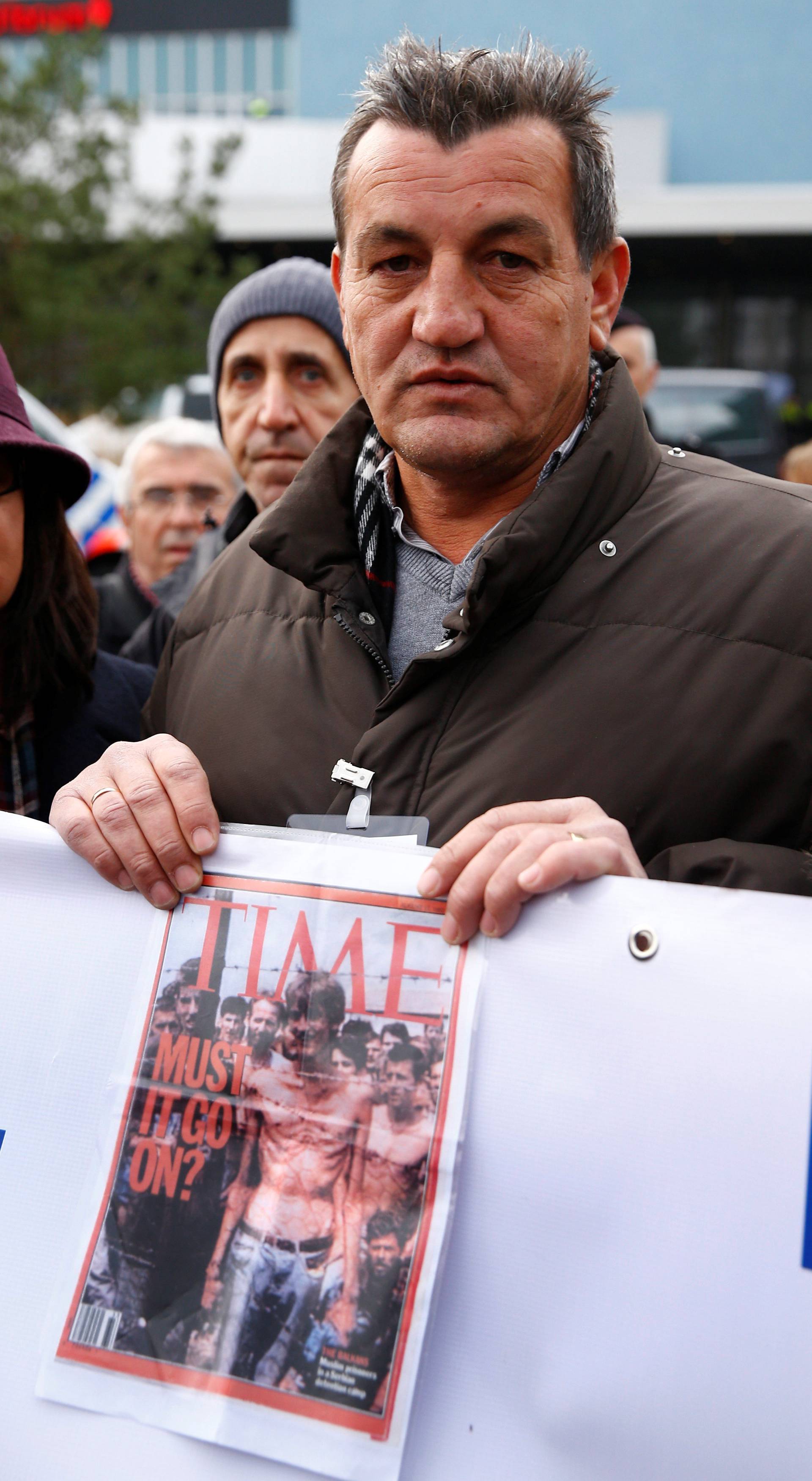 Fikret Alic, one of the survivors of concentration camps shows his photo on the cover of Time before the trial of former Bosnian Serb military commander Ratko Mladic before a court at the International Criminal Tribunal for the former Yugoslavia (ICTY) in