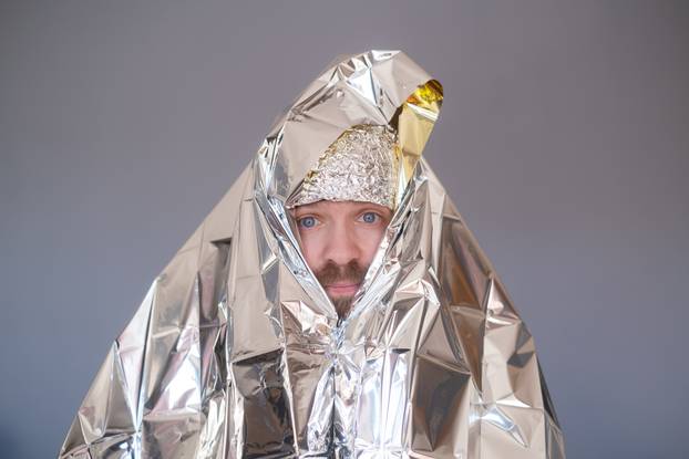 Lost hiker wrapped in an emergency survival blanket