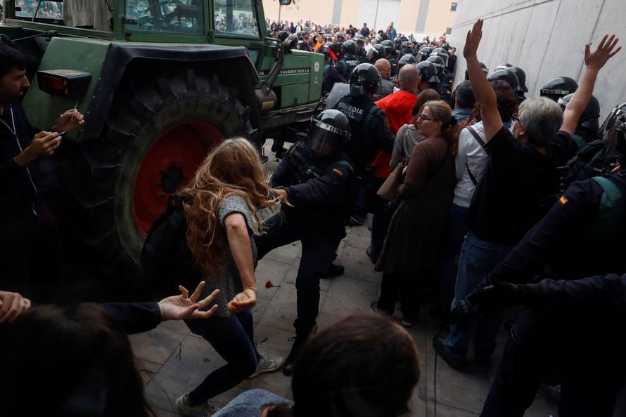 A Spanish Civil Guard officer scuffles with a woman outside a polling station for the banned independence referendum where Catalan President Puigdemont was supposed to vote in Sant Julia de Ramis