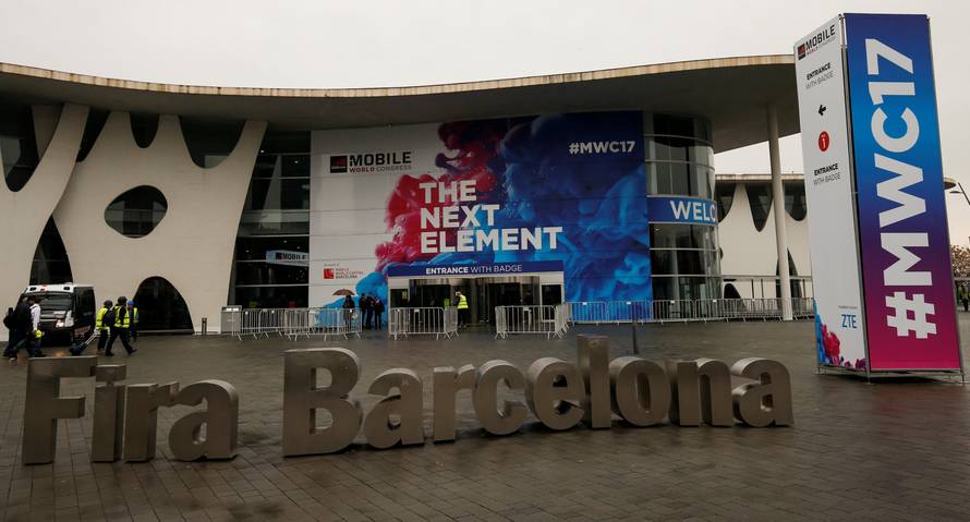 Workers walk past the main entrance of the Mobile World Congress in Barcelona