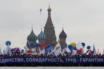 People carry a banner in front of St. Basil's Cathedral during a May Day rally at Red Square in Moscow