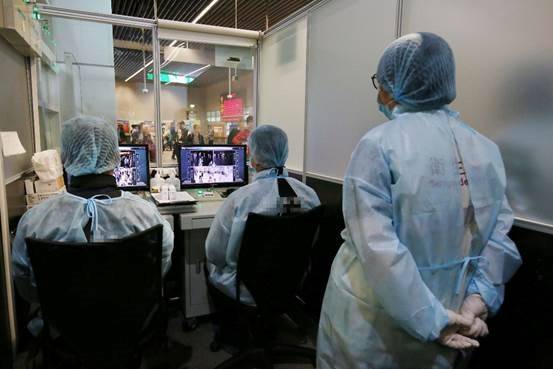 Officials monitor thermal scanners at a temperature monitoring station at Portas do Cerco in Macau
