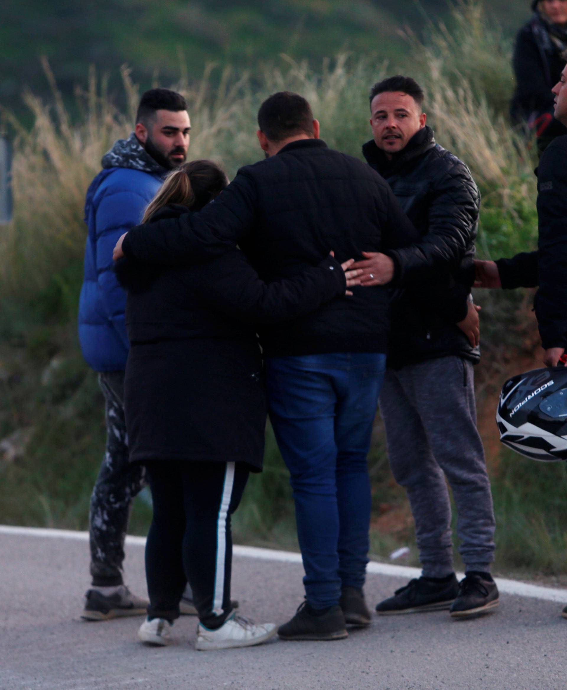 People comfort each other on a road after leaving the area where Julen, a Spanish two-year-old boy who fell into a deep well four days ago in Totalan