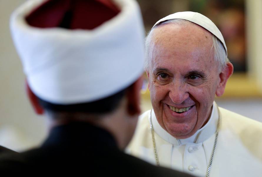 Pope Francis smiles to a member of the delegation as he meets with Sheikh Ahmed Mohamed el-Tayeb, Egyptian Imam of al-Azhar Mosque, at the Vatican