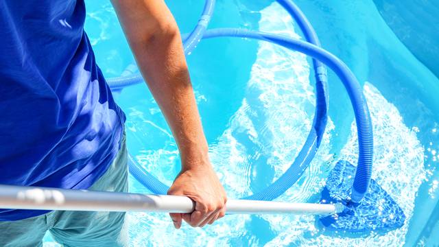 Swimming,Pool,Cleaning.,A,Man,Is,Cleaning,The,Pool.,Service