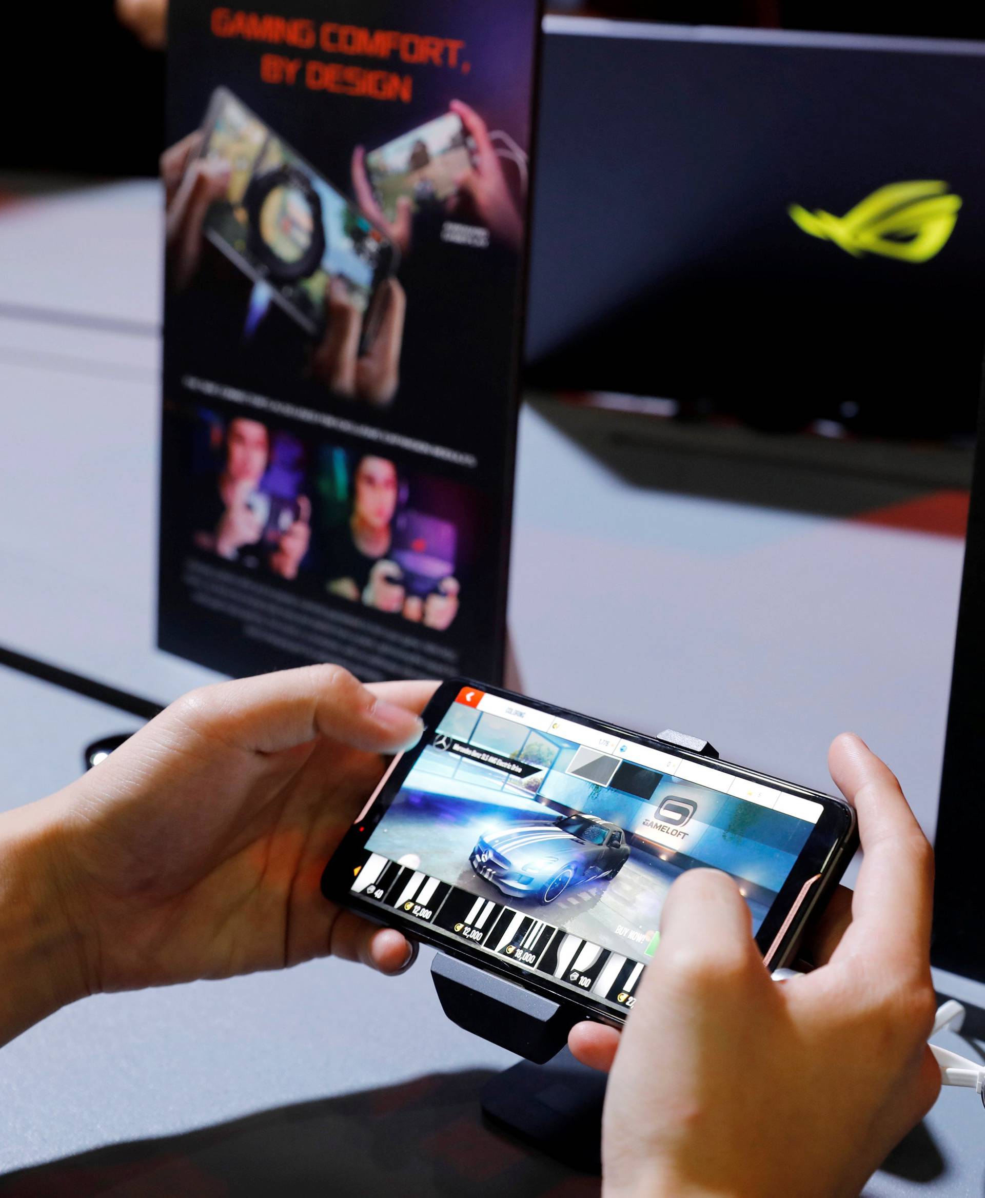 A visitor plays Asus Republic of Gamers's ROG gaming phone during the annual Computex computer exhibition in Taipei