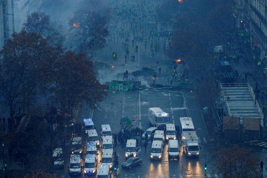A view shows a barricade with police forces and protesters wearing yellow vests, a symbol of a French drivers' protest against higher diesel taxes, during clashes as part of a demonstration near the Place de l'Etoile in Paris