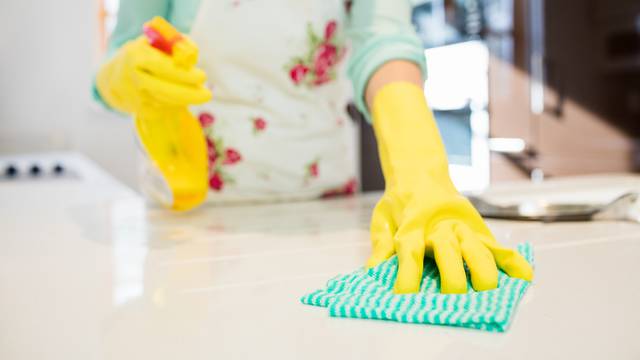 Woman cleaning kitchen worktop