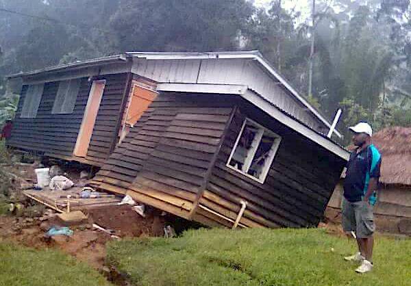 A local stands next to a damaged house near a landslide in the town of Tari after an earthquake struck Papua New Guinea's Southern Highlands