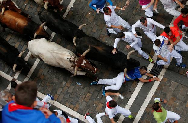 Runners sprint ahead of bulls during the fourth running of the bulls at the San Fermin festival in Pamplona