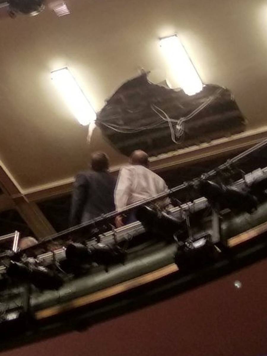 People look at the collapsed roof of Piccadilly Theatre during 'Death of a Salesman' play in London