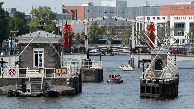 FILE PHOTO: A boat cruises past a bridge on a canal in Amsterdam