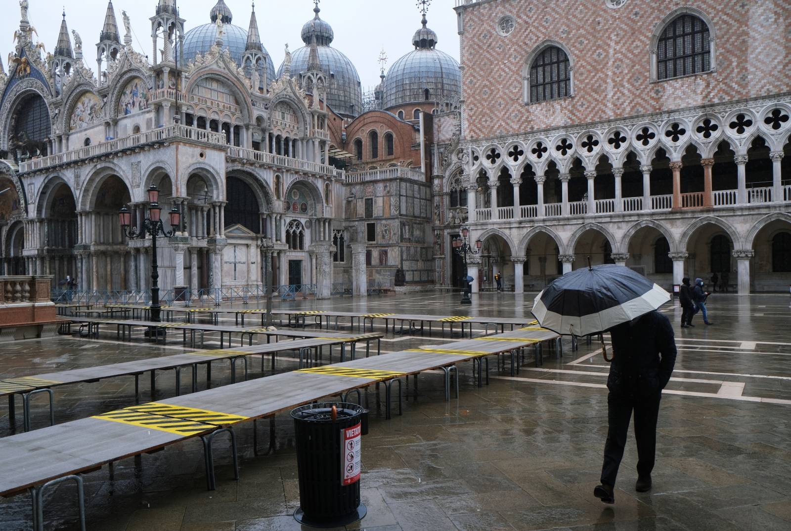A man walks in St. Mark's Square during high tide as the flood barriers known as Mose are raised for the second time, successfully protecting the lagoon city from flooding, in Venice