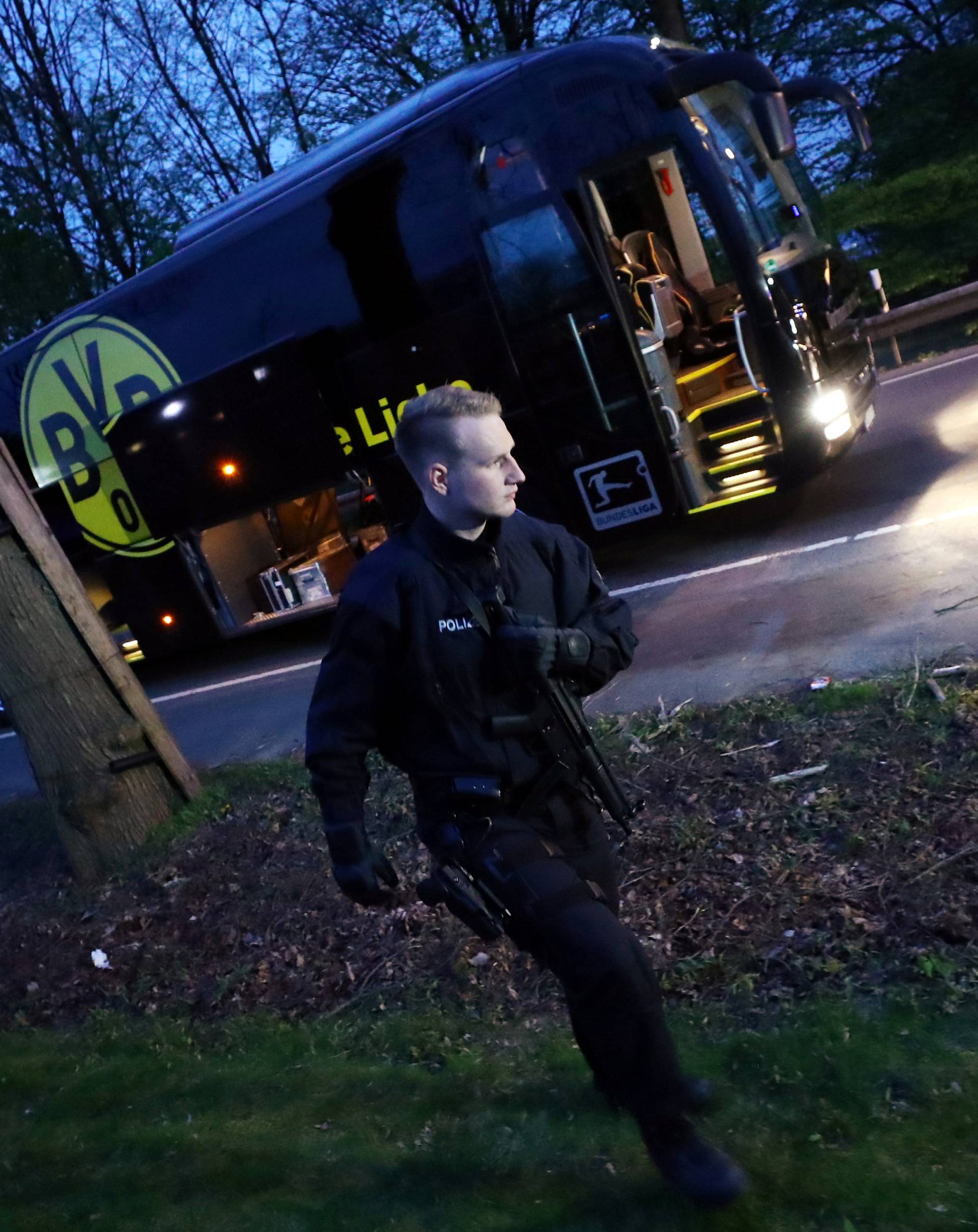 Police with the Borussia Dortmund team bus after an explosion near their hotel before the game