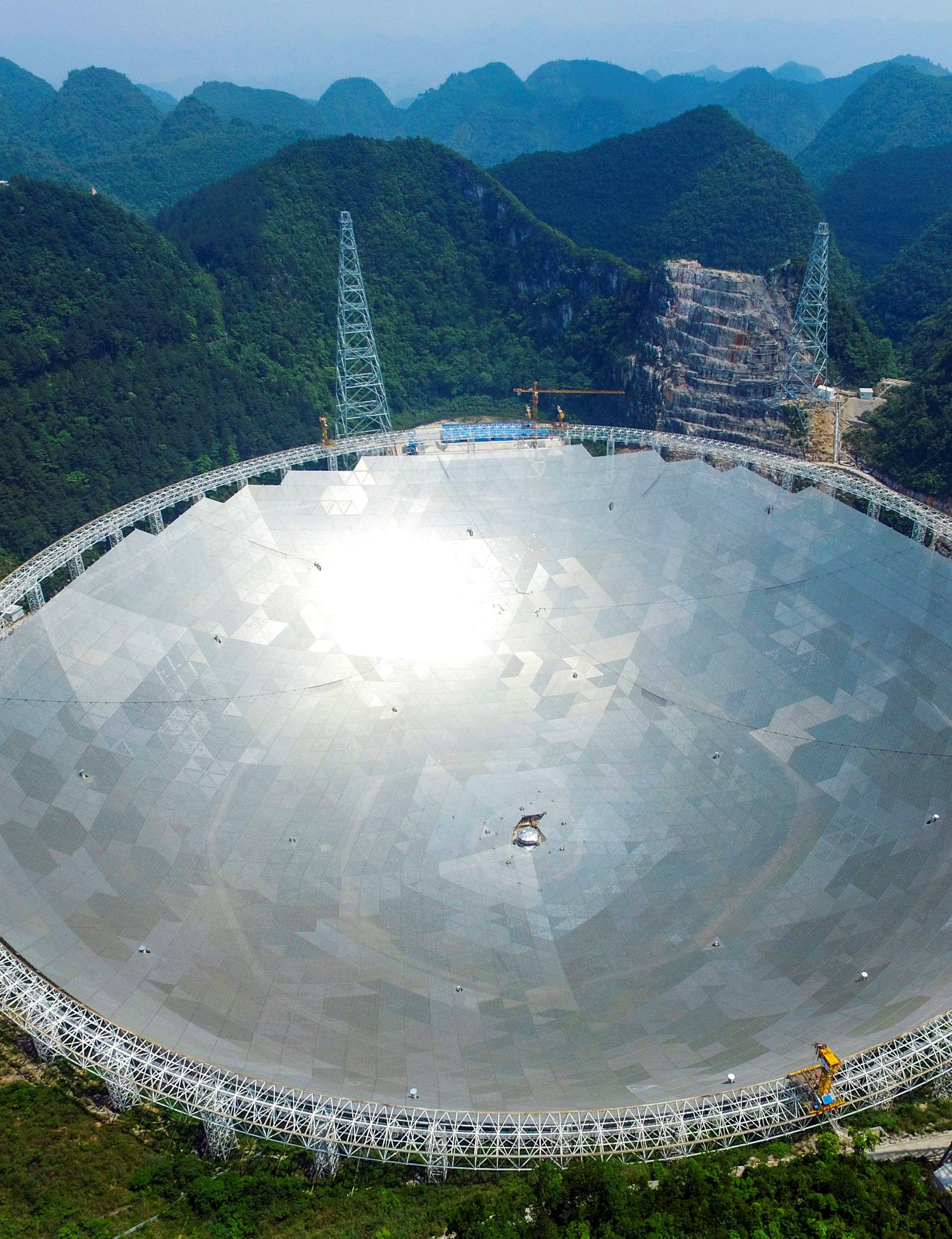 A 500-metre aperture spherical telescopeis seen at the final stage of construction, among the mountains in Pingtang county