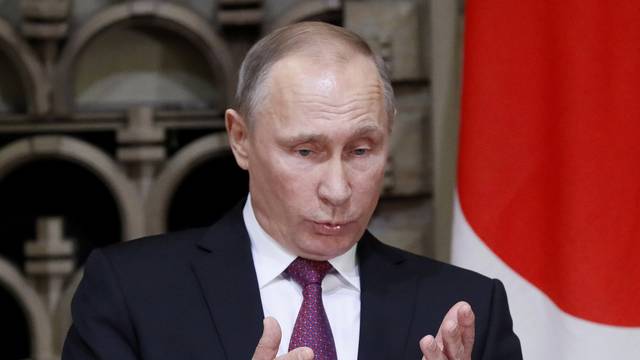 Russian President Vladimir Putin gestures as he speaks during a joint news conference with Japanese Prime Minister Shinzo Abe in Tokyo, Japan