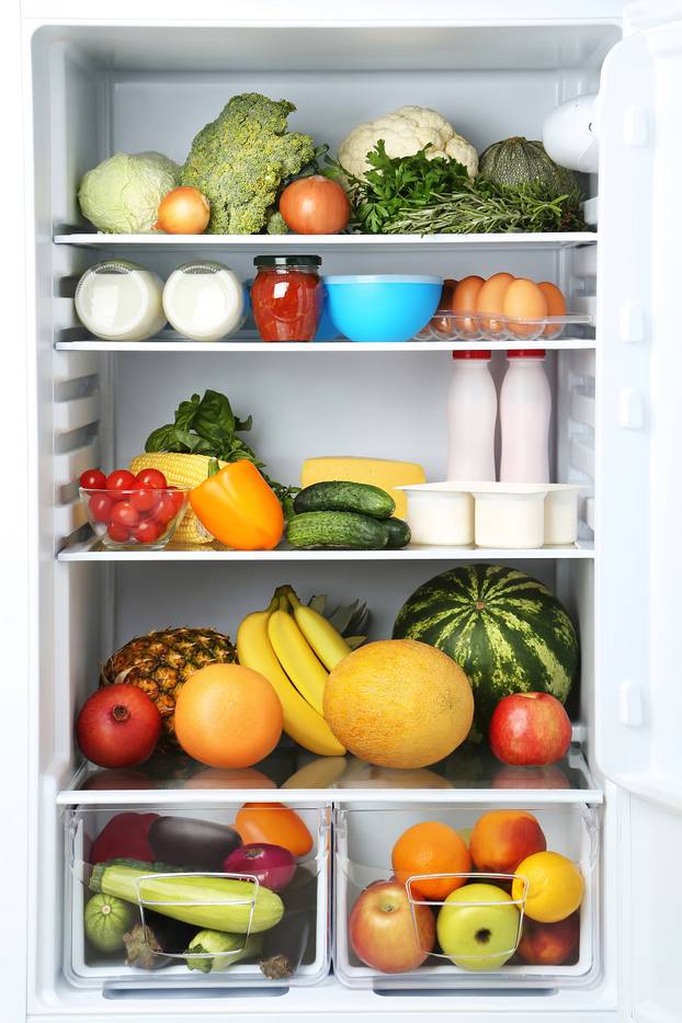 Open fridge full of vegetables and fruits