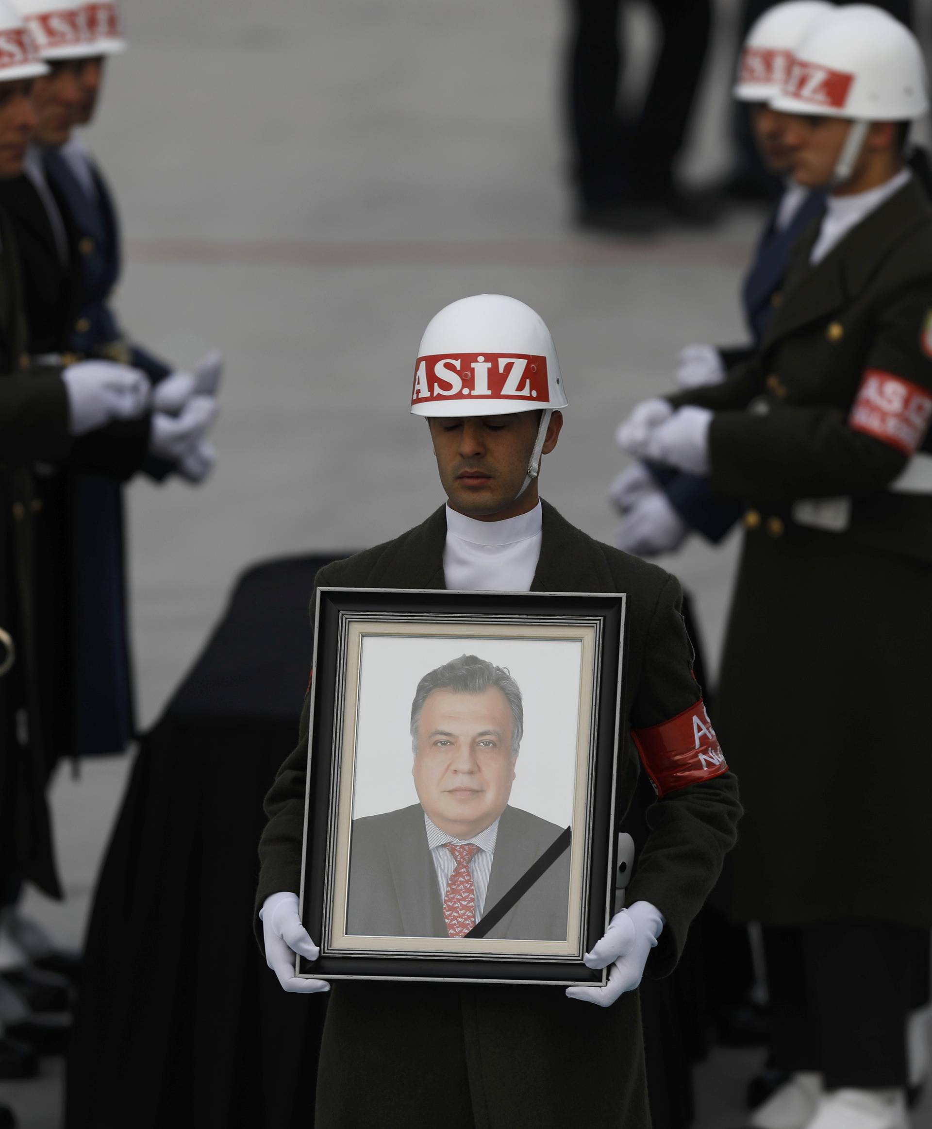 Honor guard holds a picture of late Russian Ambassador to Turkey Karlov during a ceremony at Esenboga airport in Ankara