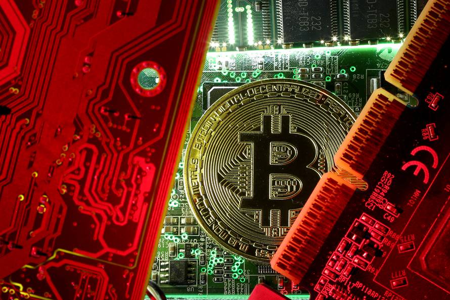FILE PHOTO: A copy of bitcoin standing on PC motherboard is seen in this illustration picture