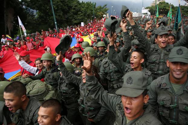 Civilians and members of the National Bolivarian Armed Forces parade during a military exercise in Caracas