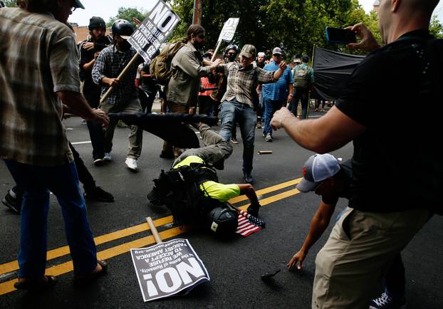 A man hits the pavement during a clash between members of white nationalist protesters against a group of counter-protesters in Charlottesville