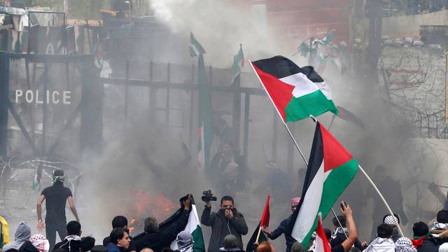 Protesters are sprayed with water near the U.S. embassy in Awkar east of Beirut