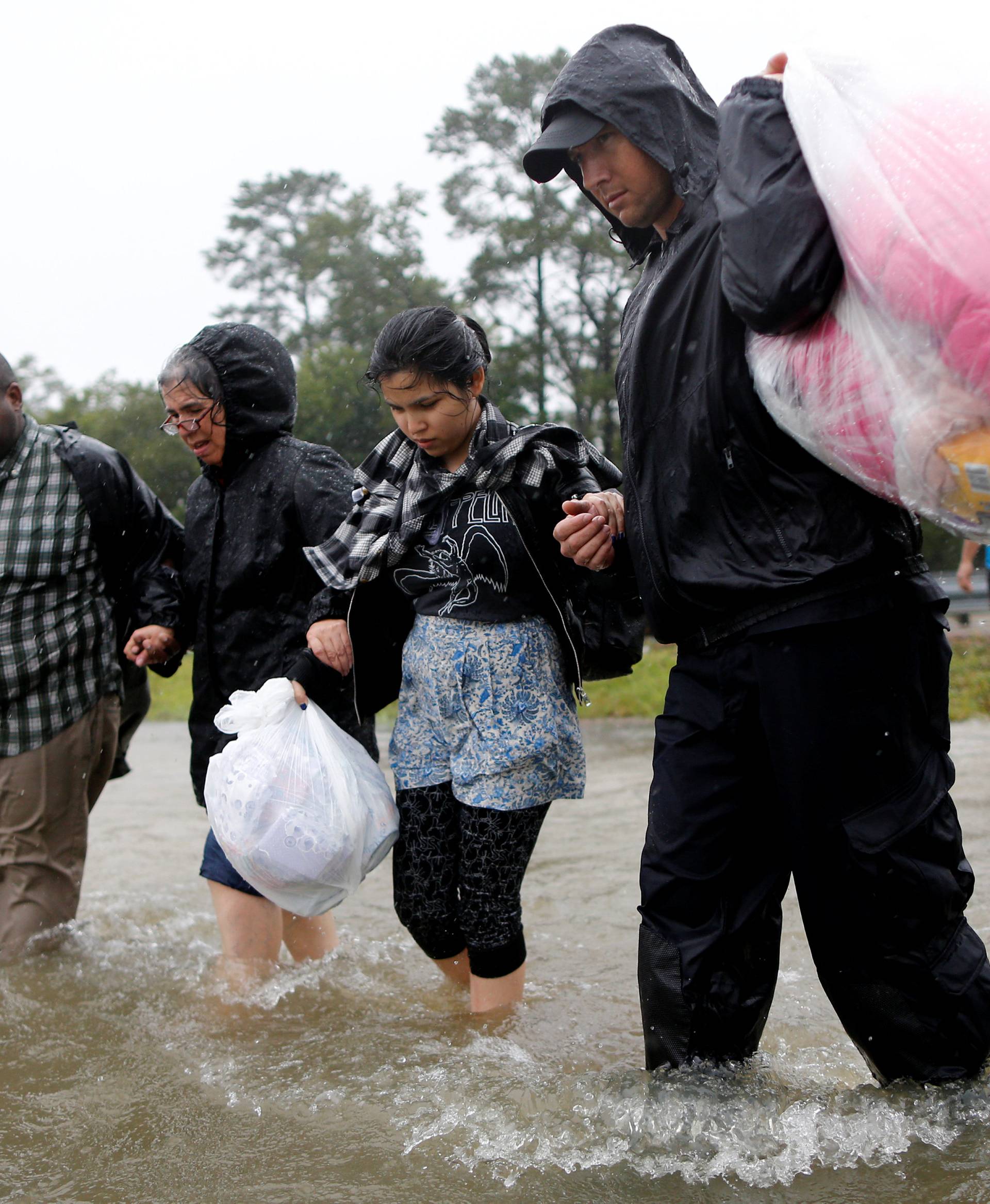 Residents wade through flood waters from tropical storm Harvey after being rescued in east Houston