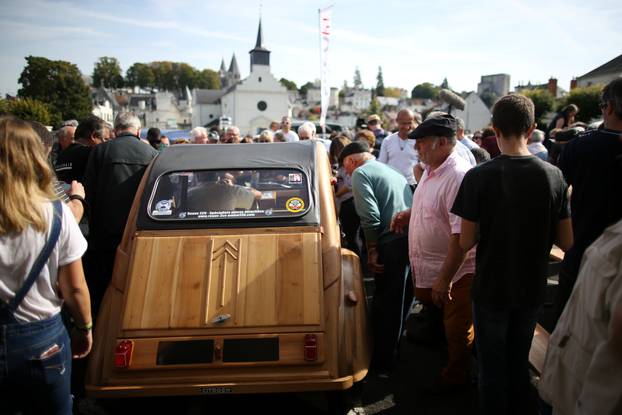 People gather around the hand-built 2CV Citroen car made out of fruitwood by Michel Robillard, a french cabinet maker, in Loches