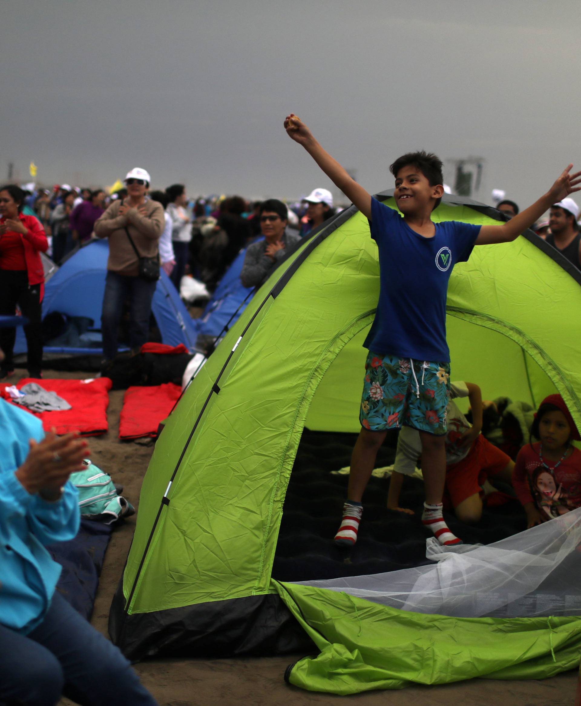 Faithfuls gather around tents a night prior to a mass by Pope Francis, on Huanchaco beach in Trujillo, Peru