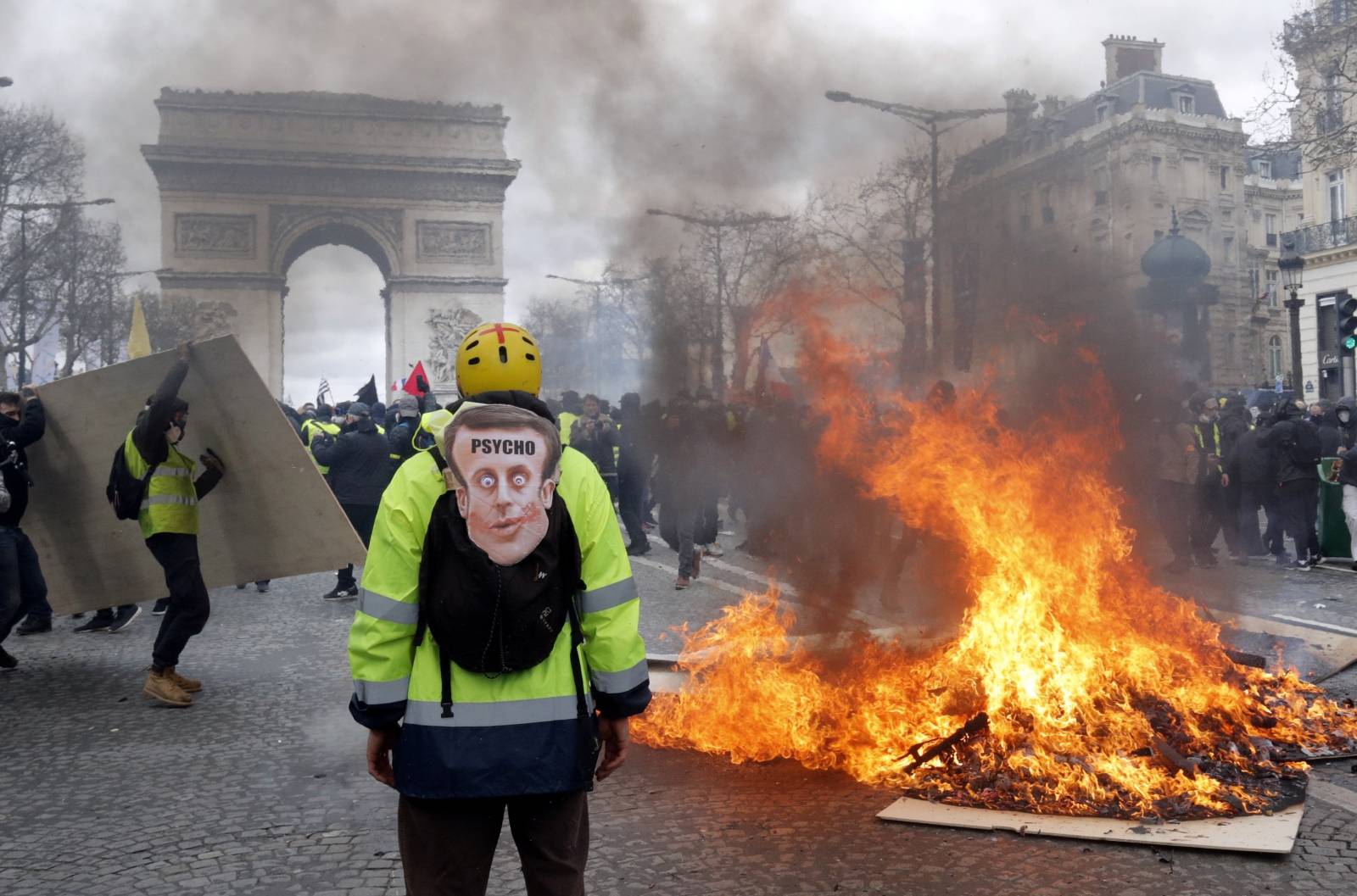 A demonstrator stands near a burning barricade during a demonstration by "yellow vests" in Paris